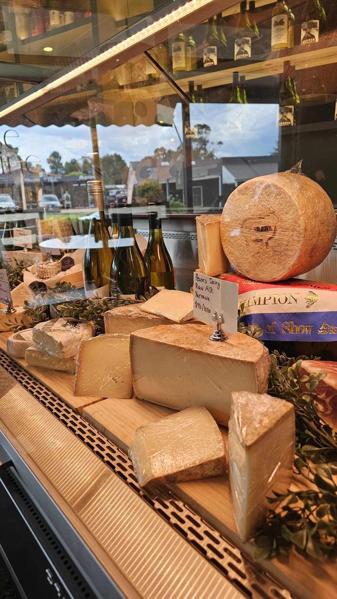 Wheels and wedges of cheese in the display at Gibson of Robertson