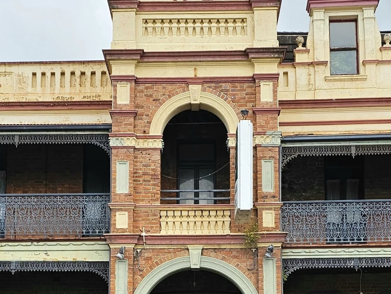 The ornate brick and sandstone facade of the Heritage Hotel in Bulli, with its iron lace verandahs