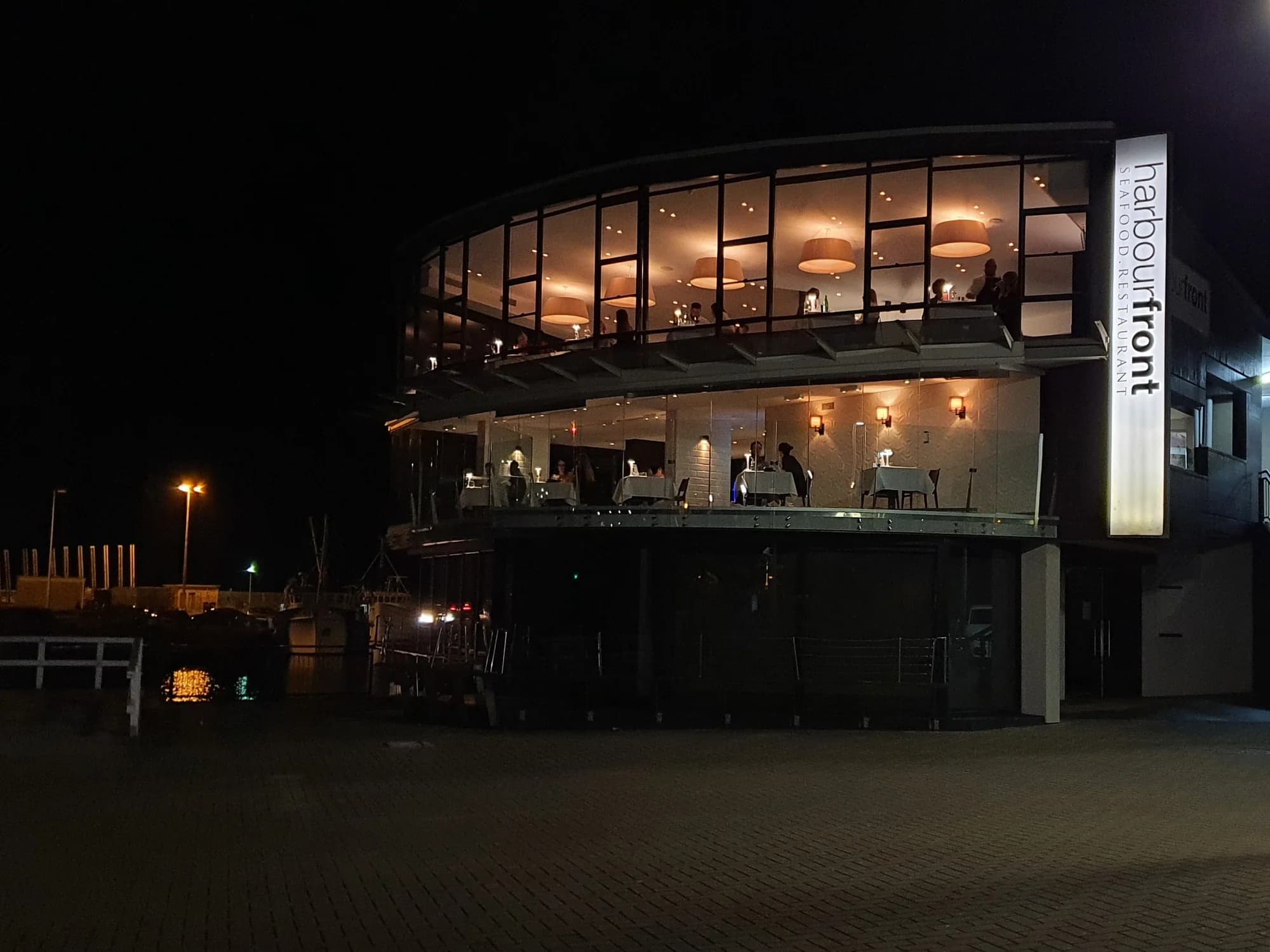 The Harbourfront restaurant glowing at night beside Belmore Basin